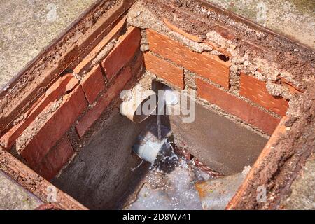 Bau-Schachtloch für die Wasserableitung mit pvc-Rohren Stockfoto