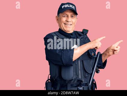 Senior gutaussehender Mann in Polizeiuniform lächelnd und Blick auf die Kamera zeigt mit zwei Händen und Fingern zur Seite. Stockfoto