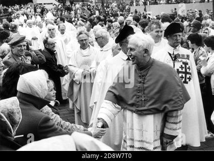 KARDINAL BASIL HUME GEHT BEI DER RÖMISCH-KATHOLISCHEN MESSE ZUM 100. JAHRESTAG AUF DEM GUILDHALL-PLATZ IN PORTSMOUTH UNTER DIE MENSCHENMASSEN. 1983 PORTSMOUTH Stockfoto