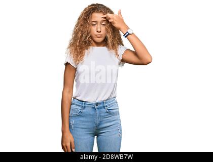 Schöne kaukasische Teenager-Mädchen tragen beiläufige weiße T-Shirt zeigt unglücklich Pickel auf der Stirn, hässliche Infektion der Mitesser. Akne und Haut probl Stockfoto