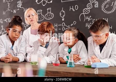 SchoolKids beobachten verschiedene Reaktionen in Glasröhrchen mit chemischen Verbindungen Stockfoto