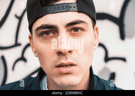 Porträt eines ernsthaften jungen attraktiven kaukasischen Mann in einem Baseballmütze, die in die Kamera schaut Stockfoto