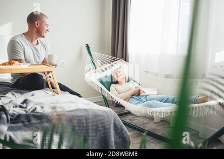 Junge Familie verbringen Zeit Spaß machen, während zu Hause sitzen. Glückliches Paar, das eine gute Zeit zu Hause hat Stockfoto