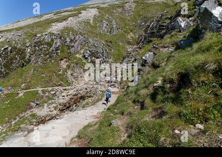 Wanderer kühlen sich im Wasserfall auf dem Gipfelweg ab Ben Nevis Highlands Schottland Stockfoto