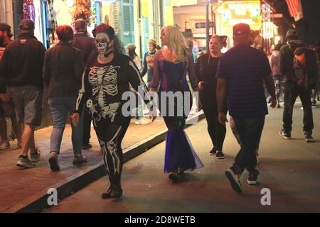 New Orleans, USA. November 2020. Menschen, die Halloween-Kostüme tragen, gehen am 31. Oktober 2020 auf einer Straße in New Orleans, Louisiana, USA. Aufgrund der COVID-19 Pandemie waren die öffentlichen Versammlungen in New Orleans begrenzt und alles schloss am Samstag um 11 Uhr. Quelle: Lan Wei/Xinhua/Alamy Live News Stockfoto