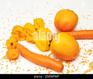 Herbstkonzept der orangen Farbe. Kaki, Karotte, Pfeffer, rote Linsen auf weißem Hintergrund. Gesunde Ernährung, vegetarische Gerichte. Zutaten zum Kochen Stockfoto