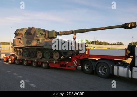 Überstandardmäßiger, atypischer Straßentransport. Ein Haubitzer auf dem Tankgehäuse. Außergewöhnlicher Konvoi. Langes Fahrzeug. Stockfoto