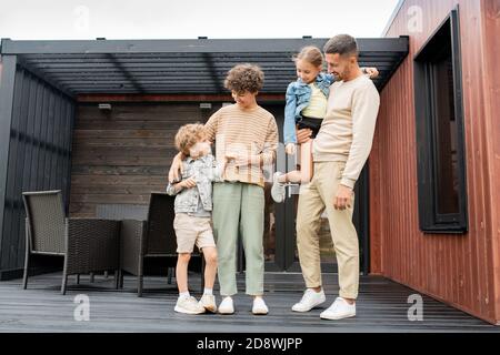 Erholsame Familie von jungen Eltern und ihre beiden entzückenden kleinen Kinder in legerer Kleidung Stockfoto