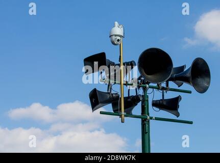 Tannoy-System und Überwachungskamera gegen einen blauen Himmel Stockfoto