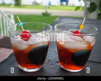 Zwei alte Fashioneds in Groovy Gläser mit einem See Hintergrund Stockfoto