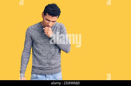 Hispanische gut aussehende junge Mann trägt lässigen Pullover Gefühl unwohl und Husten als Symptom für Kälte oder Bronchitis. Health Care Konzept. Stockfoto