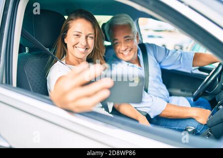 Mittelalterpaar verliebt sitzt im Auto gehen Für eine Reise, die ein Selfie-Bild mit Smartphone lächelt Glücklich und fröhlich zusammen Stockfoto