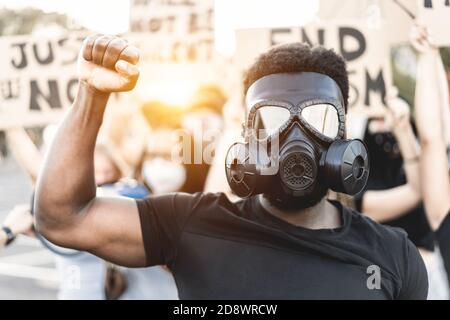 Menschen aus verschiedenen Kulturen und Rassen protestieren auf der Straße Für Gleichberechtigung - Fokus auf schwarze Gasmaske Stockfoto
