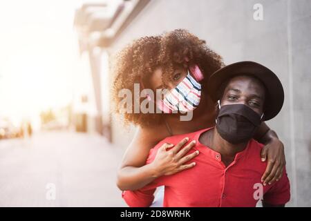 Afrikanisches Paar mit Spaß im Freien tragen Gesichtsmasken - Fokus Auf die Augen des Menschen Stockfoto