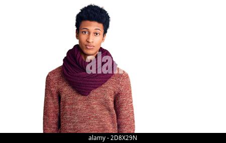 Junger afroamerikanischer Mann in lässigem Winterpullover und Schal sieht schläfrig und müde aus, erschöpft von Müdigkeit und Kater, faule Augen am Morgen Stockfoto