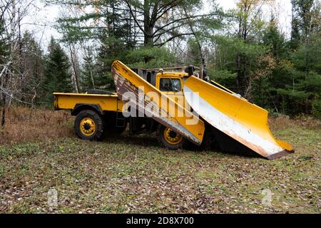 Ein alter schwerer Schneepflug, der in einem abgelegenen Gebiet der Adirondack Mountains, NY USA, geparkt ist, um im Winter die Holzfällerstraßen offen zu halten. Stockfoto