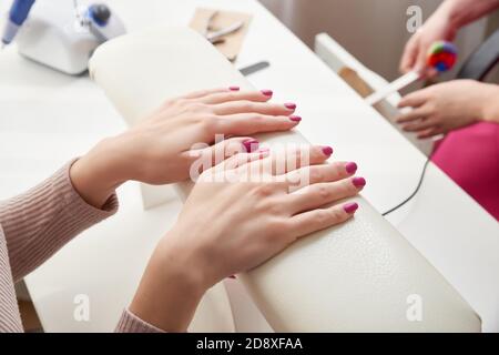 Oung Frau tut Maniküre im Salon. Schönheitskonzept. Stockfoto