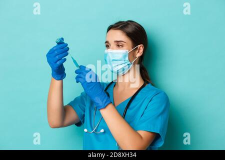 Konzept von covid-19 und Quarantänekonzept. Bild einer Ärztin in medizinischer Maske, Handschuhen und Peelings, Füllen einer Spritze mit Coronavirus-Impfstoff Stockfoto