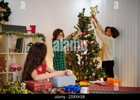 Kinder schmücken Weihnachtsbaum Stockfoto