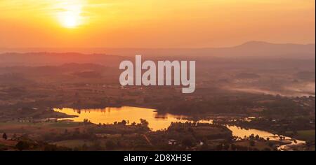 Landschaft Luftaufnahme eines Sees mit Sonnenuntergang über Bergen im Hintergrund, Winterszene in Khao Kho, Thailand. Stockfoto