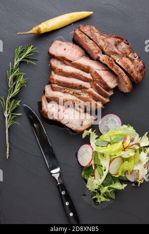 Gebratenes Schweinefleisch befindet sich auf einem Steinplateau Stockfoto