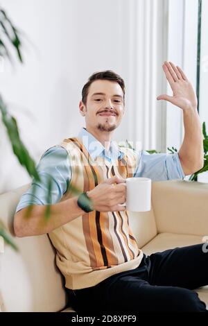 Lächelnder Mann winkt mit der Hand Stockfoto