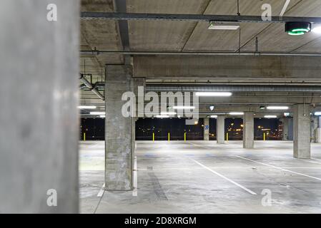 Leeres Parkhaus mit weichem Fokus. Leere Parkgarage verschwommen. Parkhaus im Einkaufszentrum am Abend, Stockfoto