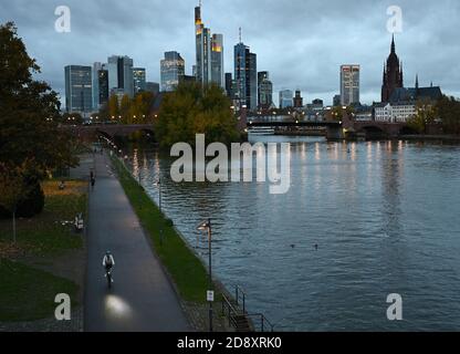 02. November 2020, Hessen, Frankfurt am Main: Am frühen Morgen sind Radfahrer und Jogger am Mainufer unterwegs. Eine vierwöchige Teilsperre hat in ganz Deutschland begonnen, um die Ausbreitung des Corona-Virus zu verlangsamen. Foto: Arne Dedert/dpa Stockfoto