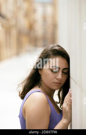 Traurige Frau lehnte sich an der Wand in der Straße Augen geschlossen Stockfoto