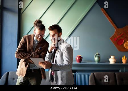 Portrait glücklicher Geschäftsleute, die digitale Geräte bei der Besprechung nutzen Stockfoto