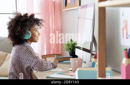afroamerikanische Kind Mädchen online lernen am Computer zu Hause. Stockfoto