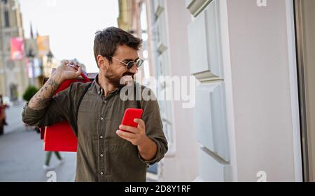 Stattliche attraktiver Mann lächelnd Shopping in der Stadt Stockfoto