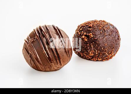 Schokoladentrüffel Bonbons mit fließender Schokolade und Kakaopulver auf weißem Hintergrund isoliert bedeckt. Makro Stockfoto