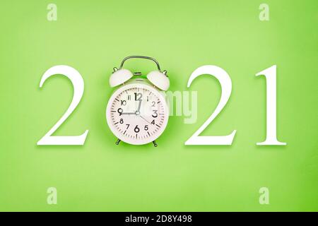 Wir feiern das neue Jahr. Neue 2021 Jahr mit Wecker auf hellgrünem Hintergrund gemacht. Neues Jahr im Lockdown Stockfoto