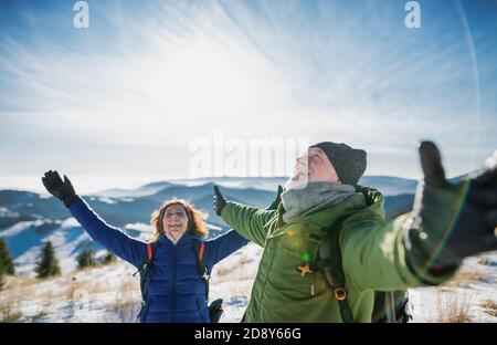 Ältere Paar Wanderer in schneebedeckten Winter Natur, Stretching Arme. Stockfoto