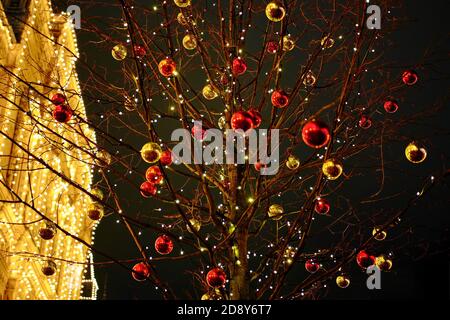 Gelbe und rote Weihnachtskugeln auf einem Baum als Element der Dekoration Stadtstraßen für das neue Jahr Stockfoto