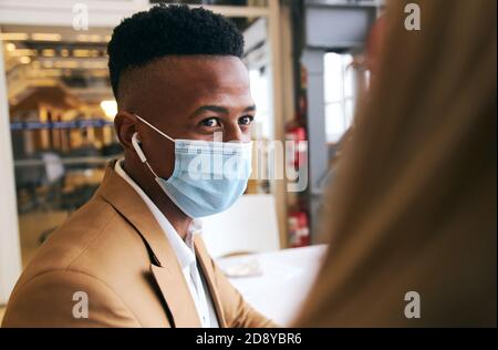 Business-Paar Trägt Masken Treffen Am Hot Desk In Modernen Büro Während Gesundheit Pandemie Stockfoto