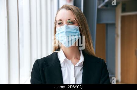 Porträt Der Jungen Geschäftsfrau Trägt Maske Im Modernen Büro Stehen Während Der Gesundheitsinpandemie Stockfoto