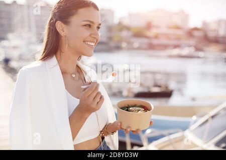 Glückliche Frau mit Schüssel Fitness Essen im Freien Stockfoto