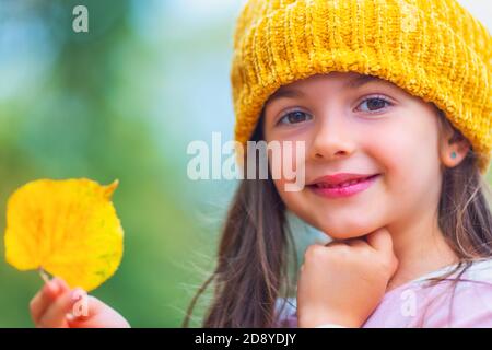 Portrait von glücklichen jungen Mädchen spielen mit gefallenen Farbe Blätter im herbstlichen Park. Kleines Kind genießt auf Herbstbäumen und Herbst. Stockfoto