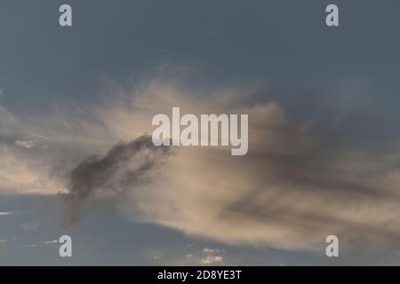 Detail von kleinen grauen und weißen Wolken in blau/grauem Himmel. Flüchtig, temporär. Frühling, Queensland, Australien. Hintergrund, Kopierbereich. Stockfoto