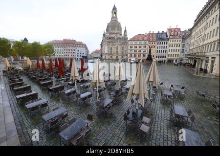 Dresden, Deutschland. November 2020. Leere Stühle und Tische stehen auf dem Neumarkt vor der Frauenkirche vor einem Restaurant. Ab dem gleichen Tag haben sich Bund und Länder für eine teilweise Sperrung entschieden. Unter anderem müssen Restaurants, Freizeiteinrichtungen und Kultureinrichtungen schließen. Quelle: Sebastian Kahnert/dpa-Zentralbild/dpa/Alamy Live News Stockfoto