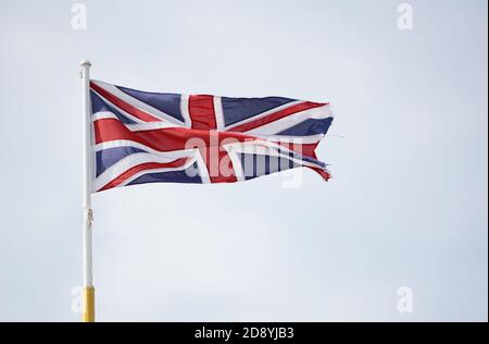 Die Flagge der Union Jack, die Schottland, Wales, Nordirland und England repräsentiert, fliegt gegen einen hellblauen Himmel Stockfoto