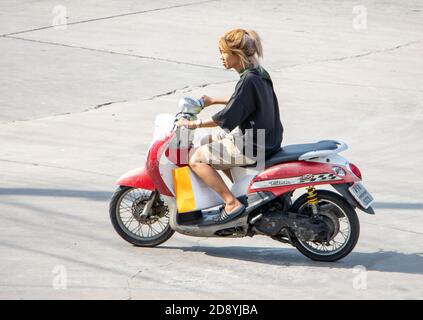 SAMUT PRAKAN, THAILAND, JULI 29 2020, EINE Frau fährt ein Motorrad auf einer sonnigen Straße. Stockfoto