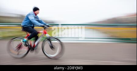 Abstraktes Bild des Radfahrers auf der Stadtstraße. Absichtliche Bewegungsunschärfe Stockfoto