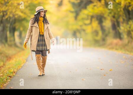 Junge modisch gekleidete Frau geht in der bunten Herbst Natur. Stockfoto