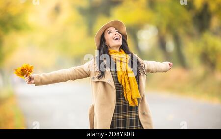 Glückliche Frau genießen Zeit im Freien halten Orangenbaum Blätter in der bunten Natur. Stockfoto