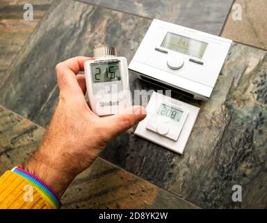 Paris, Frankreich - Oct 25, 2020: POV Mann zeigt Vaillant IoT Geräte - VRC 700f Wetterausgleichsthermostate, VR50 Thermostat Ventil und Ambisense VR51 Raumthermostat Stockfoto