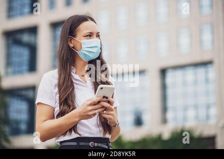 Porträt einer verantwortlichen Geschäftsfrau, die Schutzmaske trägt. Covid-19-Virus-Pandemiekonzept. Stockfoto
