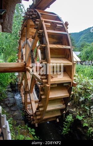 Das Mühlrad dreht sich unter einem Wasserstrahl. Stockfoto